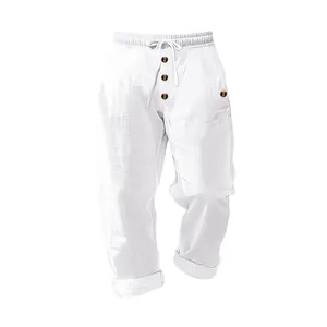 Detailed texture of white linen drawstring trousers with decorative buttons