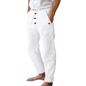 Detail shot of men's white linen pants featuring drawstring waist and decorative buttons.