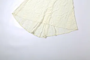 Close-up detail of the elegant high-low hem on a cream floral lace off-shoulder dress