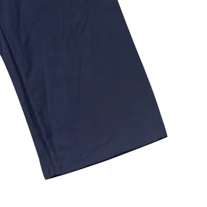 Macro detail of navy blue linen trousers hem showing fabric texture and stitching