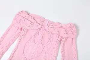 Detail of pink lace off-shoulder long sleeve dress showing fine mesh texture