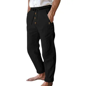 Detail of black men's linen trousers with drawstring waist and decorative buttons