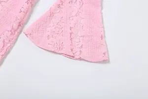 Macro view of delicate pink floral lace embroidery and bell sleeve cuff detail on dress