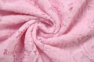 Macro close-up view of elegant pink lace fabric showing intricate floral hollow patterns