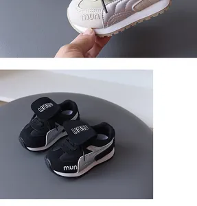 Close-up detail of children's fashion sneakers in silver and black with embroidery