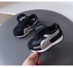Close-up detail of black and silver children's retro sneakers with soft anti-slip soles.