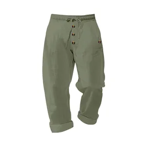 Detail view of olive green linen men's pants with drawstring waist and decorative buttons.