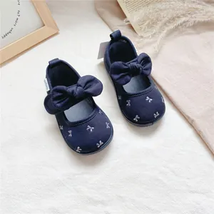 Detailed view of navy blue baby girl canvas shoes with bow and butterfly embroidery