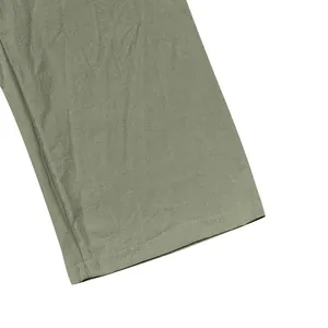 Close-up detail of sage green linen trouser hem showing high-quality stitching
