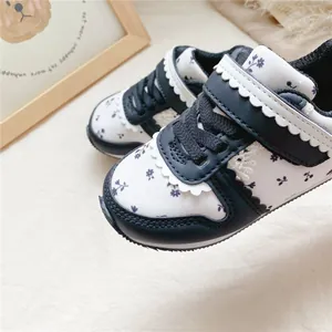 Detailansicht leichter Mädchen-Turnschuhe mit Blumenmuster und einem Wellenrand