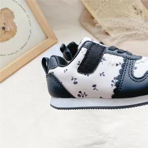 Nahaufnahme eines geblümten Mädchen-Sneakers mit detaillierten Nähten und Muster.