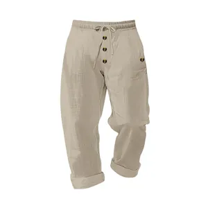 Close-up of men's loose casual linen pants with drawstring waist and button detail.