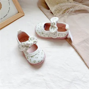 Detailed close-up of floral pattern and bow on toddler girl canvas walking shoes