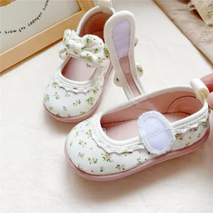 Detailed view of floral canvas toddler shoes with bow and lace trim on soft pink sole
