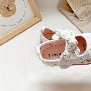 Detail view of floral print canvas baby shoes with a soft bow accent for toddlers