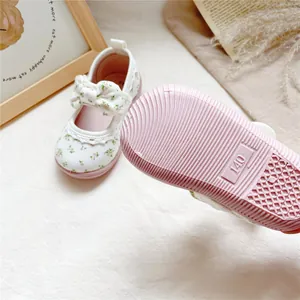 Detailed view of floral toddler canvas shoes featuring pink soft rubber sole and bow
