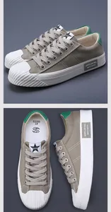 Detail view of men's casual khaki canvas sneakers with white ribbed rubber toe cap