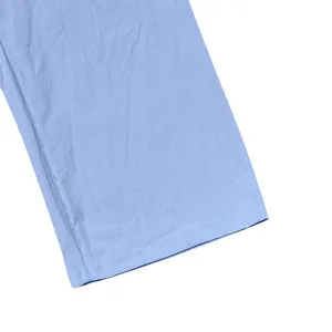 Macro view of light blue linen pants hemline showing high-quality stitching and breathable fabric texture