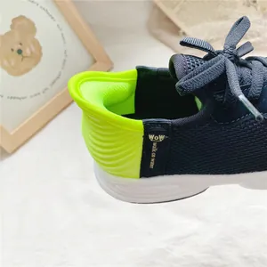Detailed view of the neon green cushioned heel on a breathable blue slip-on child sneaker