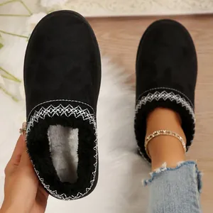 Gros plan de bottes de neige noires avec broderies et doublure en fausse fourrure.