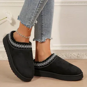 Gros plan sur des chaussons à plateforme en daim noir pour femmes avec détails brodés