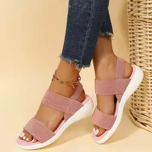 Detalle de sandalias rosas con tiras elásticas y suelas blancas gruesas en el pie