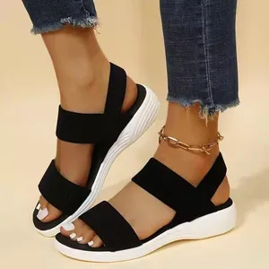 Vista detallada de sandalias negras para mujer con correas elásticas y suela de plataforma