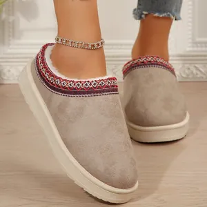 Vue détaillée des chaussons à plateforme en daim gris avec col brodé rouge décoratif