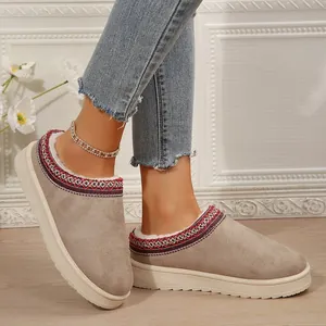 Gros plan de bottes de neige pour femmes en daim taupe avec bordure brodée colorée