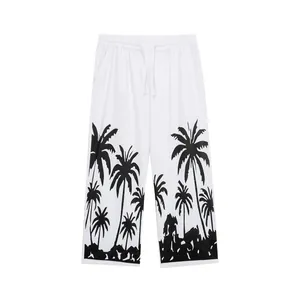 Close-up of black palm tree print on white men's casual linen wide-leg trousers
