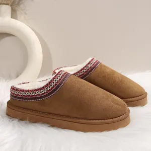 Gros plan de chaussons d'hiver en daim marron avec broderie et doublure en fausse fourrure