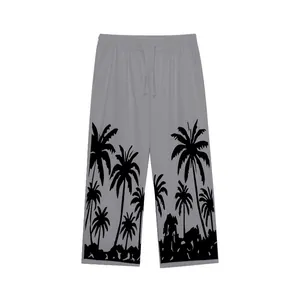 Detail view of tropical palm tree print on grey men's linen casual wide leg trousers.