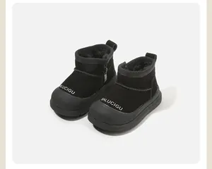 Detailed macro view of black velvet-lined baby snow boots with BALUCIGU text print