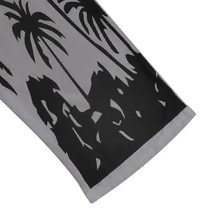 Close-up detail of the black palm tree silhouette print on grey linen fabric hemline