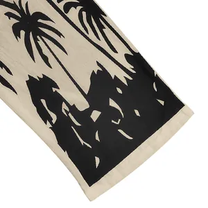 Close-up of black palm tree print on linen-textured beige summer beach trousers
