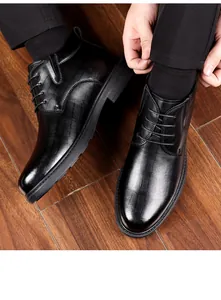 Detailed high-angle view of men's black high-top business leather boots with embossed texture