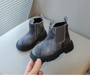 Detailed macro shot of children's grey denim texture Chelsea boots with side zipper closure.