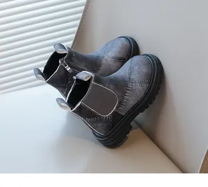 Detailed view of grey denim children's Chelsea boots featuring side zipper and treaded sole