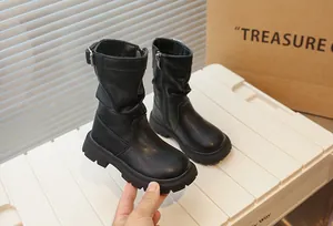 Détail de bottes mi-mollet noires pour filles avec semelles épaisses et zip latéral.