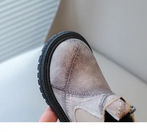 Close-up of distressed leather texture and stitching on kids' British style Martin boots.