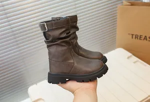 Gros plan détaillé de bottes mi-mollet marron vintage pour filles avec semelles