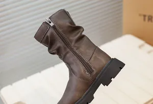Gros plan sur des bottes mi-mollet marron vintage pour filles avec fermeture éclair