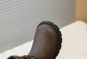 Gros plan sur le bout d'une botte marron pour fille montrant la texture du cuir et la semelle.