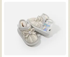 Detailed macro view of baby snow boots featuring pearl bow accents and warm fur lining