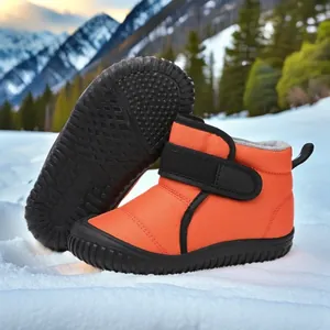 Detail of orange kids snow boots with warm fleece lining and non-slip sole.