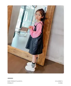 Vista detallada de zapatillas blancas de moda para niños usadas por una niña con estilo.