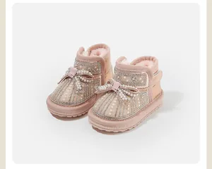 Close-up of pink toddler snow boots featuring pearl embellishments and a decorative bow.