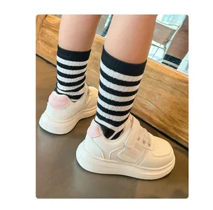Detalle de las elegantes zapatillas deportivas blancas para niños con calcetines