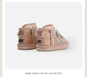 Close-up of pink toddler snow boots with rhinestone and pearl decorative detailing