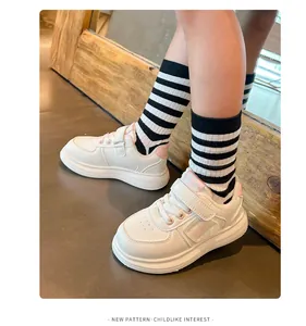 Vista detallada de elegantes zapatillas deportivas blancas para niños con detalles en rosa